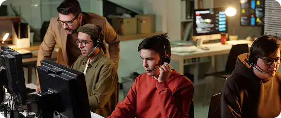 IT support team working at computers in a modern office environment.