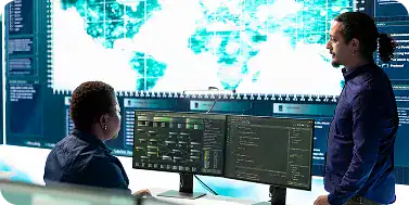 Cybersecurity professionals analyzing data on multiple monitors in a high-tech office.