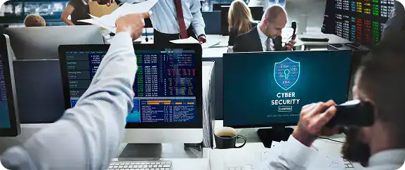 Cyber security professionals monitoring data on multiple screens.