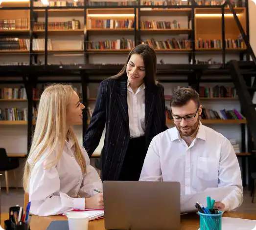 Business team collaborating in a modern office setting with bookshelves.