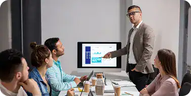 Business team discussing strategies during a presentation at i3solutions.