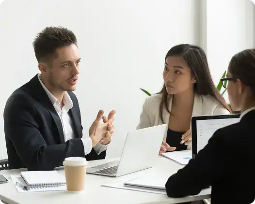 Business professionals in a meeting discussing strategies at i3solutions.
